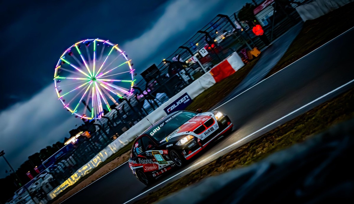 BMW E90 Eifelkind Racing nachts am Nürburgring mit Riesenrad im Hintergrund