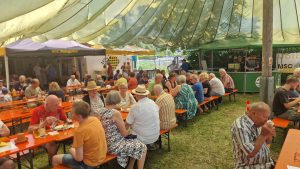 Gäste beim Haxenfest 2026 des MSC Weingarten an Bierbänken unter dem charakteristischen Fallschirmdach auf dem Clubgelände