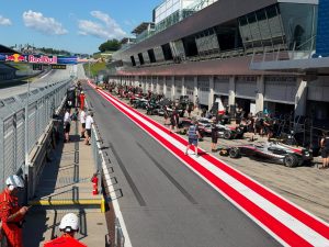 Blick auf die Boxengasse des Red Bull Rings mit Formelfahrzeugen
