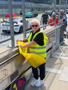 Sportwartin des MSC Weingarten mit gelber Flagge am Streckenposten des Red Bull Rings