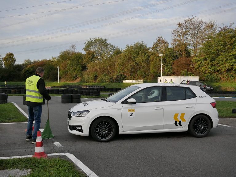 Weißer Škoda Fabia des ADAC Team Nordbaden mit Startnummer 2 am Slalom-Start, daneben ein Streckenposten mit grüner Flagge