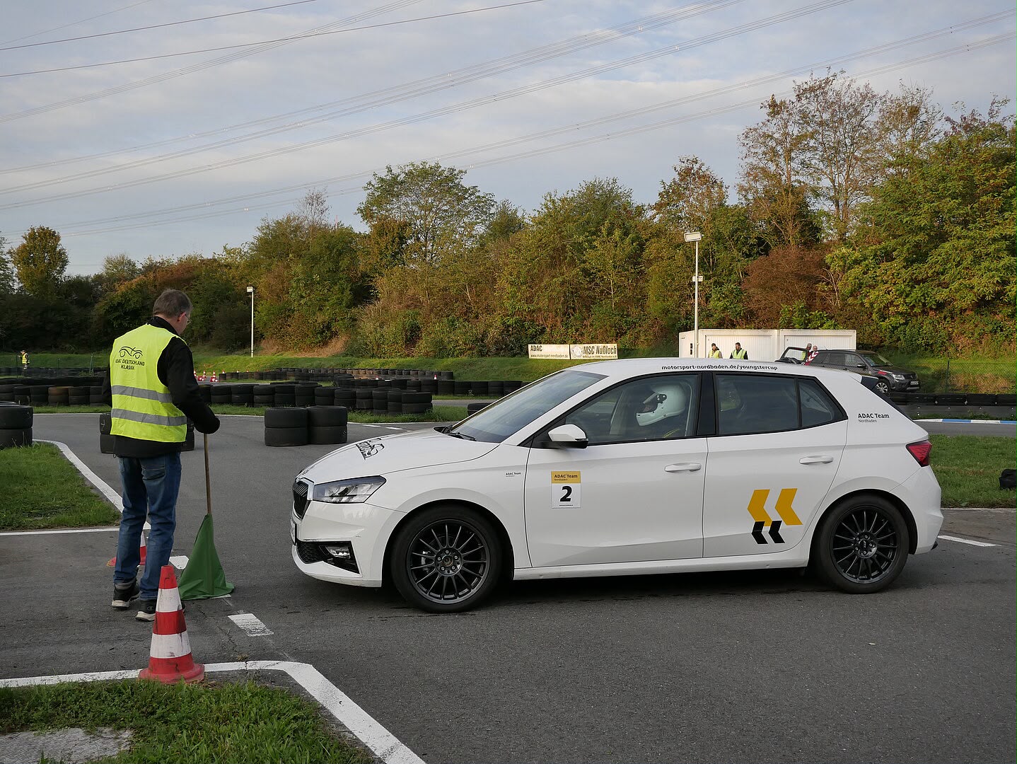 Weißer Škoda Fabia des ADAC Team Nordbaden mit Startnummer 2 am Slalom-Start, daneben ein Streckenposten mit grüner Flagge