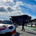 Porsche-Rennwagen in der Startaufstellung vor der Tribüne