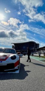 Porsche-Rennwagen in der Startaufstellung vor der Tribüne