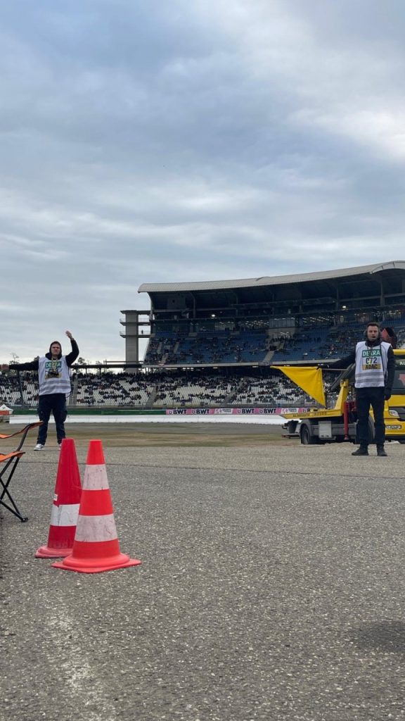 Helfer mit Flagge an der Strecke, daneben Pylonen und Abschleppwagen vor der Tribüne am Hockenheimring
