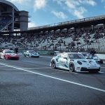 Porsche-Rennwagen in der Startaufstellung vor der vollbesetzten Haupttribüne des Hockenheimrings