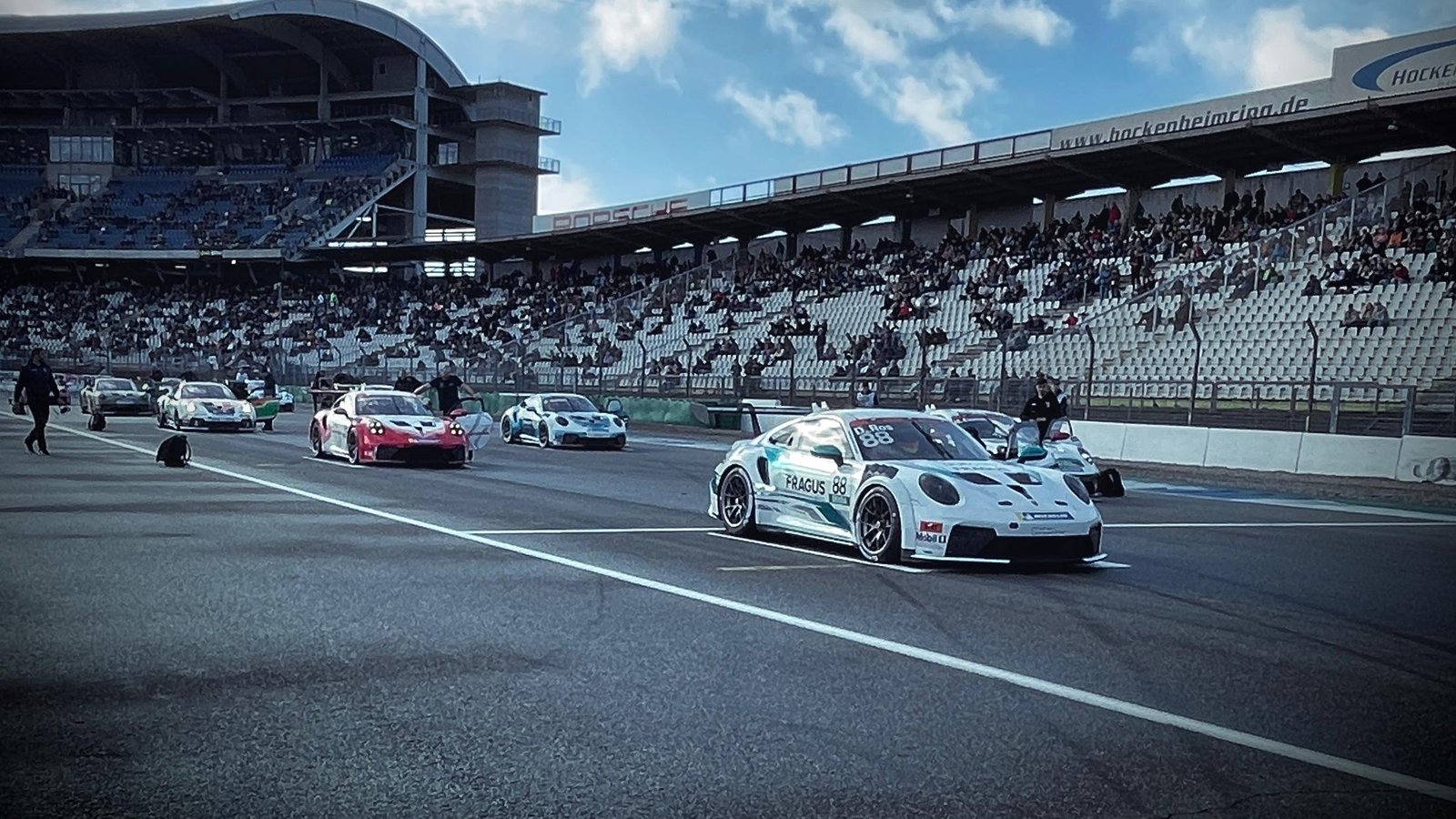 Porsche-Rennwagen in der Startaufstellung vor der vollbesetzten Haupttribüne des Hockenheimrings